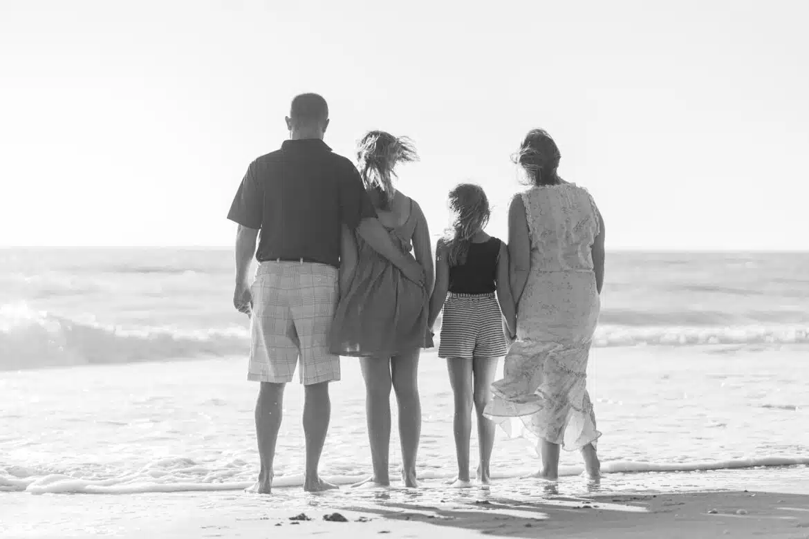 man and woman walking on beach during daytime