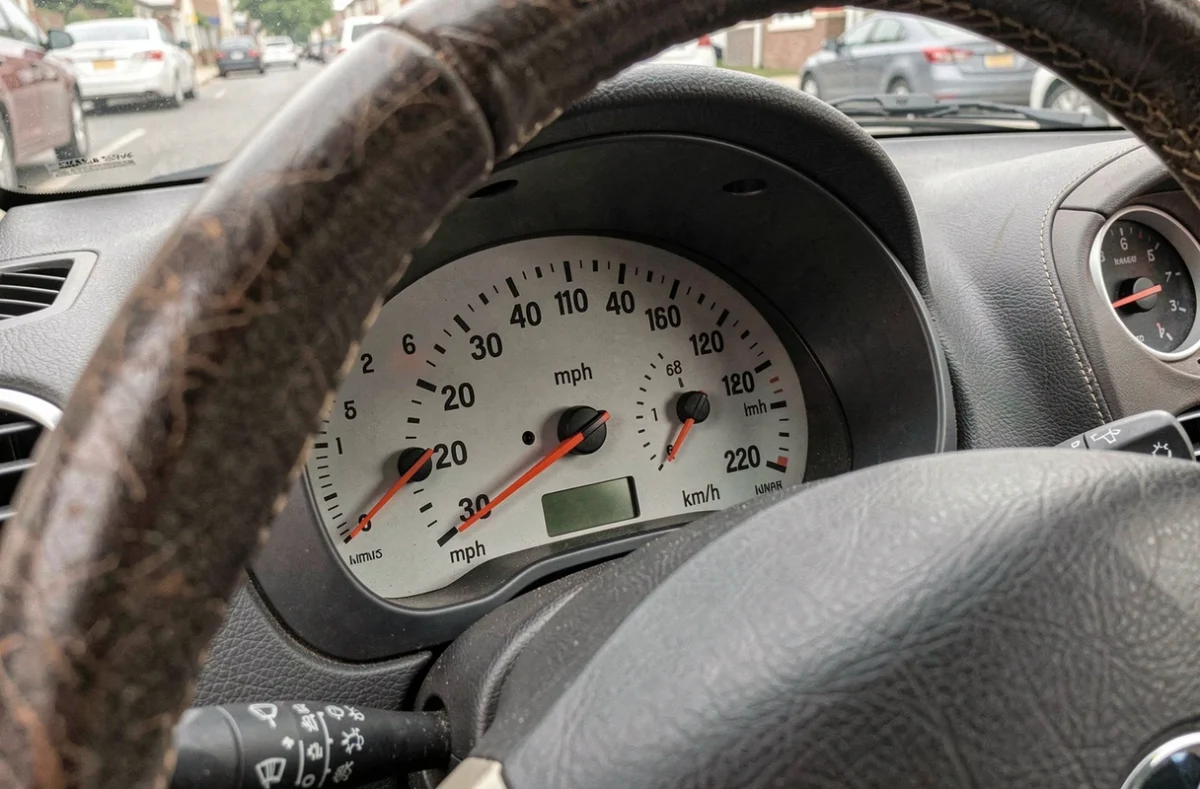 Gros plan sur le compteur de vitesse d'une voiture britannique affichant 30 mph et la correspondance en km/h sur le cadran